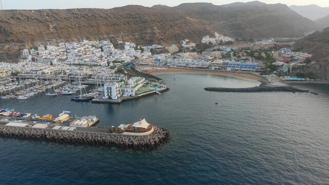 Beautiful aerial perspective of the charming port town of Puerto de Mogan in Gran Canaria, featuring the marina, beach, and white buildings