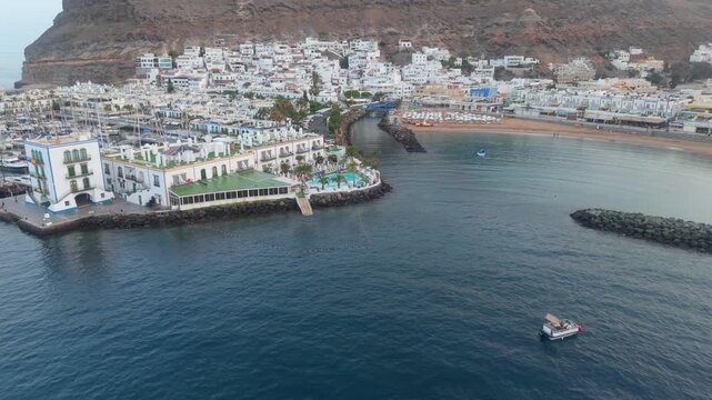 Beautiful aerial perspective of the charming coastal village of Puerto de Mogan in Gran Canaria, featuring its marina, beach, and cliffs at sunrise