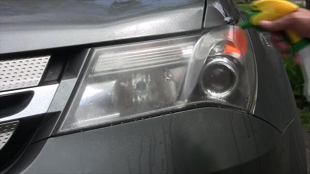 Closeup of a car headlight with condensation inside the lens, showing moisture droplets and fogging on the surface of a modern vehicles front light assembly