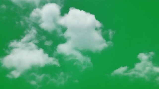 Fluffy white clouds floating in clear blue sky. Soft cotton-like cumulus formations for green screen compositing.