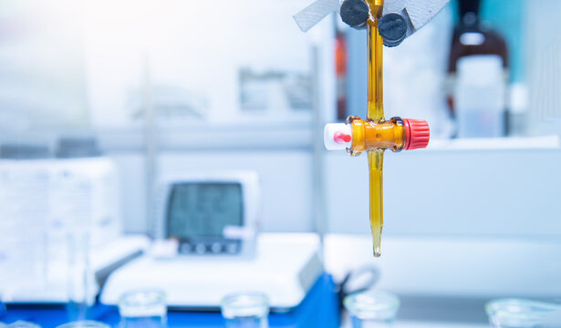 Burette filled with yellow liquid in laboratory.
