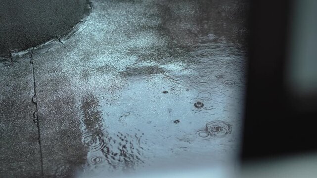 部屋の窓から覗く強く降る雨