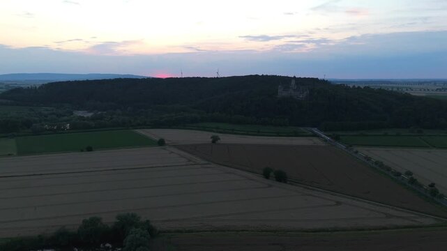 Marienburg Castle on a forested ridge during pink sunset near Hannover