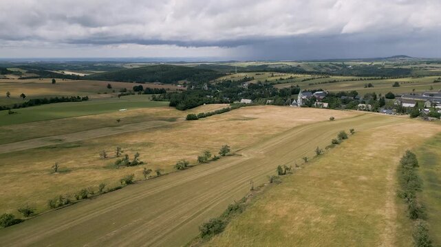 A high-angle aerial view captures the sweeping expanses of the rolling plateaus and agricultural meadows near F&uuml;rstenau in the Eastern Ore Mountains. Beautiful mountain landscape stretches across the 
