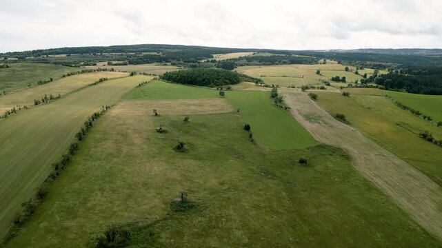 A high-angle aerial view captures the sweeping expanses of the rolling plateaus and agricultural meadows near F&uuml;rstenau in the Eastern Ore Mountains. Beautiful mountain landscape stretches across the 