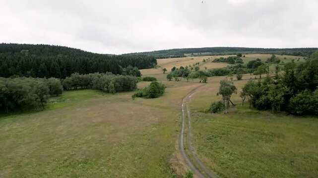 A high-angle aerial view captures the sweeping expanses of the rolling plateaus and agricultural meadows near F&uuml;rstenau in the Eastern Ore Mountains. Beautiful mountain landscape stretches across the 
