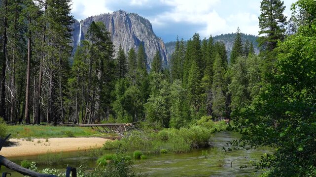 Static shot, locked camera. Yosemite Valley with a majestic waterfall flowing down the cliffs. Natural movement of cascade