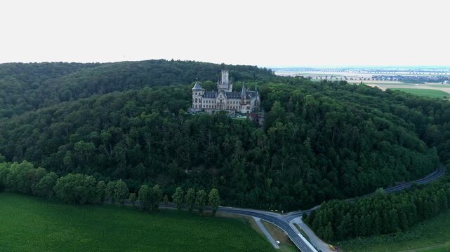 Marienburg Castle majestic rising above forest with a road below