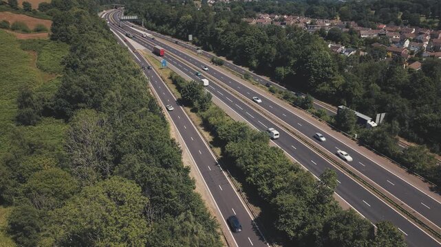 Static overhead drone shot of the M4 motorway near Cardiff, South Wales, United Kingdom. The fixed aerial perspective resembles a traffic monitoring camera, capturing continuous movement of cars, vans
