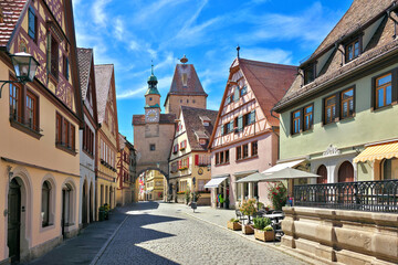 Fototapeta premium Picturesque street of colorful half timbered buildings and medieval Markus Tower in the town of Rothenberg ob der Tauber, Bavaria, Germany