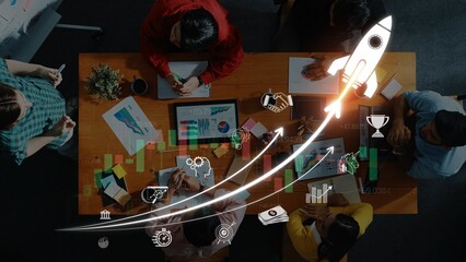 Team Collaboration on Business Strategy with Digital Graphs and Rocket Graphic Illustrating Growth...