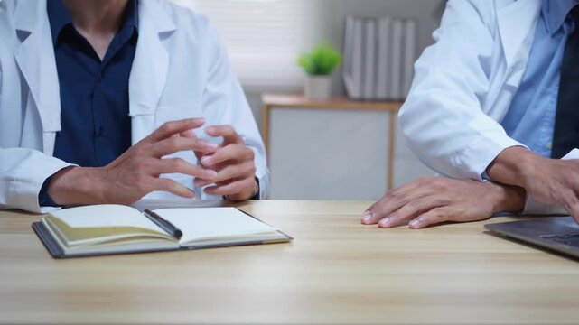 Two medical doctors discussing a case during a professional meeting in a hospital conference room