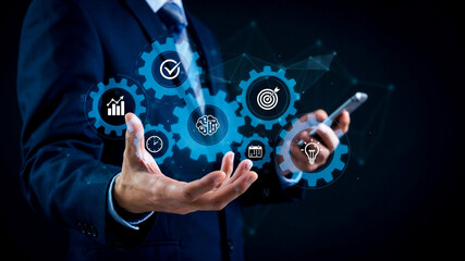 Fototapeta premium Businessman interacting with a digital interface showing gears and icons, symbolizing process, strategy, and data management