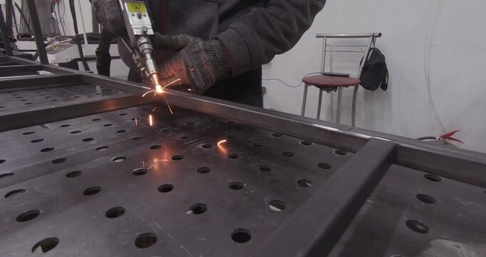 A skilled worker welds metal beams. Metal structures specialist.