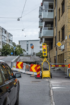 Road construction site with temporary traffic light and barriers.