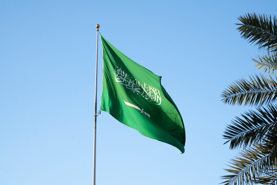 Saudi Arabian National Flag Waving Against Clear Blue Sky