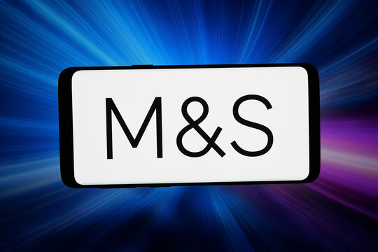 Stuttgart, Germany - 07-15-2026: In this photo illustration, the logo of British retail company Marks and Spencer plc is displayed on a smartphone in front of abstract background on computer screen.