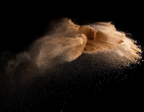 sand particles explosion on black background