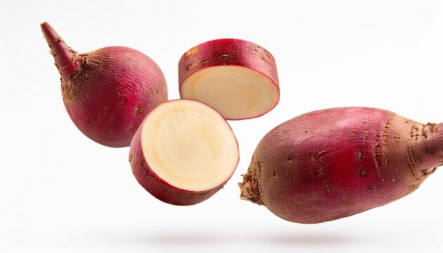whole and sliced beatroot floating on thr white background