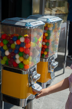 A gumball machine containing colorful round gumballs
