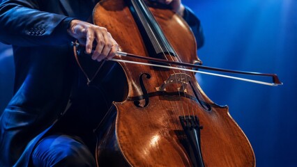 Fototapeta premium Cellist performing with cello on dimly lit concert stage