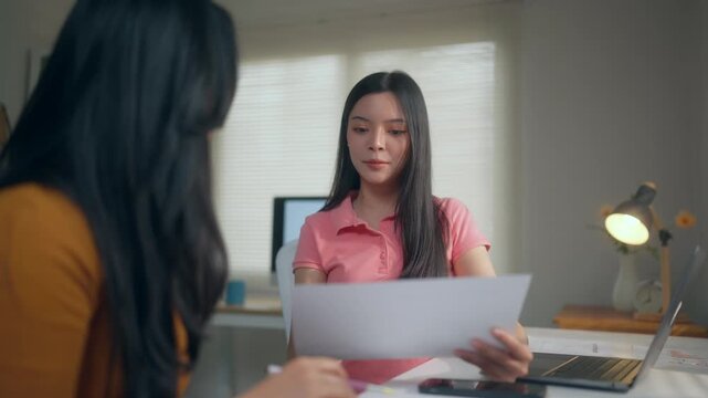 Human resources manager reviewing a candidate's resume during a job interview at the office