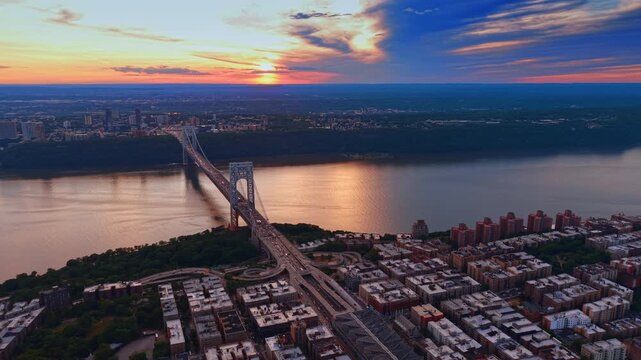 The Hudson River dazzled by the setting sun. View on the the George Washington Bridge from drone.