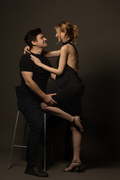 A pregnant slim girl poses with her husband in black outfits