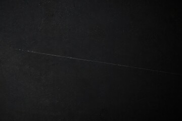 Fototapeta premium Scratched Matte Texture Backdrop. Faint diagonal line on dark worn surface symbolizing imperfection endurance and resilience in minimalist aesthetic style background.