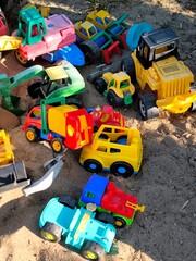 Multicolor plastic toy cars in a children's sandbox. © Irina