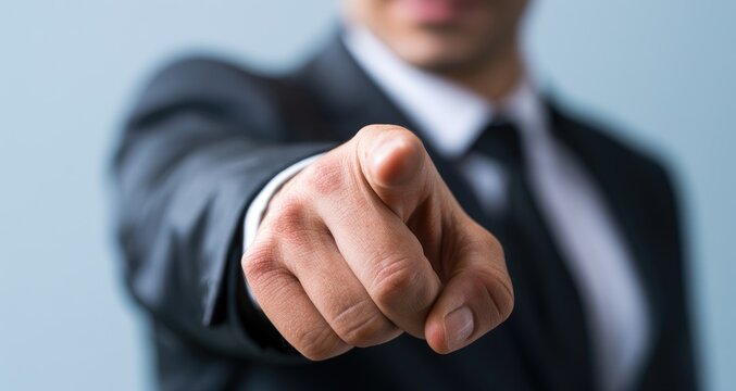 A person in a suit points directly at the viewer