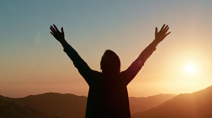 Fototapeta premium Person with arms raised in triumph against a vibrant sunset over hills