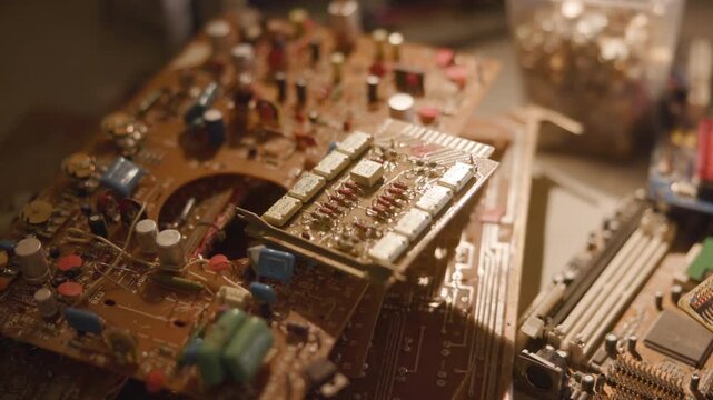 Tilted expansion board lifted from stacked circuit boards on warm lit workbench, showing visible gap, angled metal bracket, connectors, traces, and careful handling