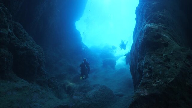 cave diving underwater scuba divers exploring caves and having fun ocean scenery sun beams and rays background