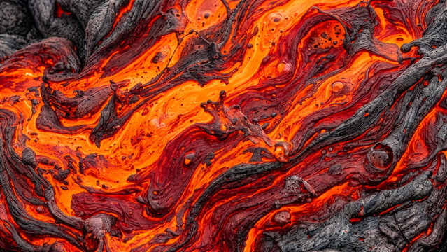 Close up of molten glowing red lava flowing over dark volcanic rock texture