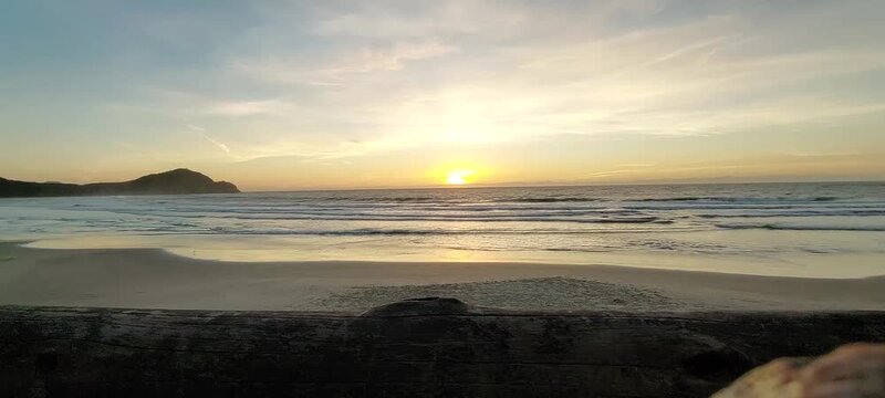 Sunrise over Praia do Rosa beach with clouds and coastal landscape