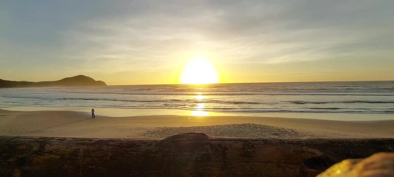 Sunlight reflecting on the sea with photographer at Praia do Rosa