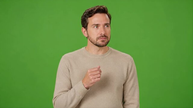 Adult actor reacts with wonder to an invisible floating object on chroma key green screen, holding open palm with clean copy space for product or VFX.