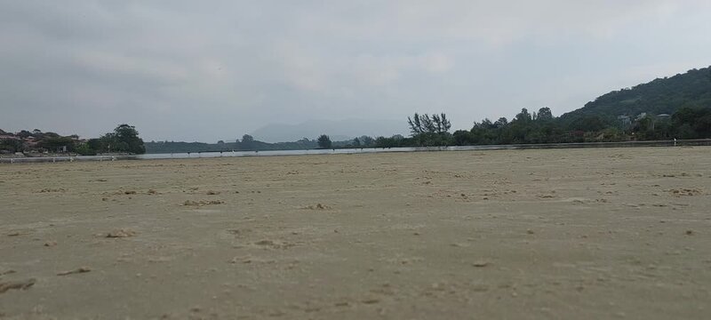 Cloudy view of barra da ibiraquera lake with birds and sandy beach