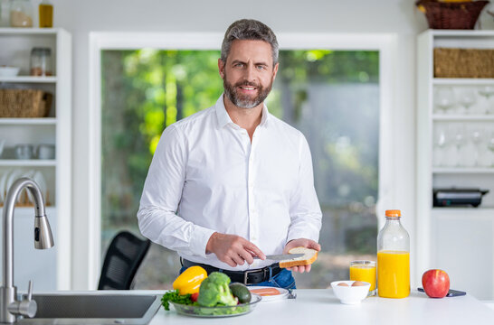 Man 40s eat healthy food in cozy kitchen. Morning breakfast in modern kitchen. Man eating healthy breakfast at home kitchen. Man eat breakfast in the kitchen. Man eating cereal with milk