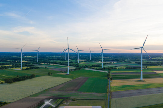 Offshore wind park. Wind turbines farm. Alternative renewable energy generation. Green energy concept. Organic harvest in farm field. Agricultural harvest. Crop cultivation. Wind turbines farm