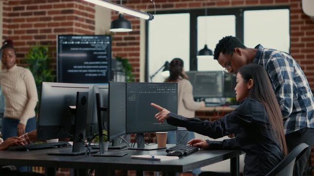 Mixed software development team reviews running code while planning a new user interface, blending brainstorming, software architecture and group problem solving, inside a focused IT agency workflow.