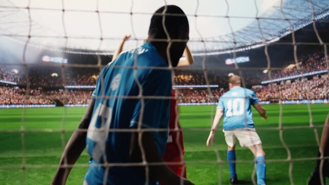 Soccer player shooting ball and hitting net by crossing line, defeated goalkeeper and teammates with missed save on pitch, selective focus inside goal frame.