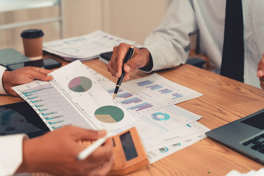 Business team presenting financial charts and marketing data during a meeting in the office.Keywords