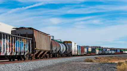 A long Union Pacific Railroad freight train featuring weathered covered hopper cars and tank cars. © hit1912