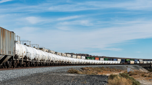 A long line of Union Pacific Railroad white tank cars stretching towards the horizon.