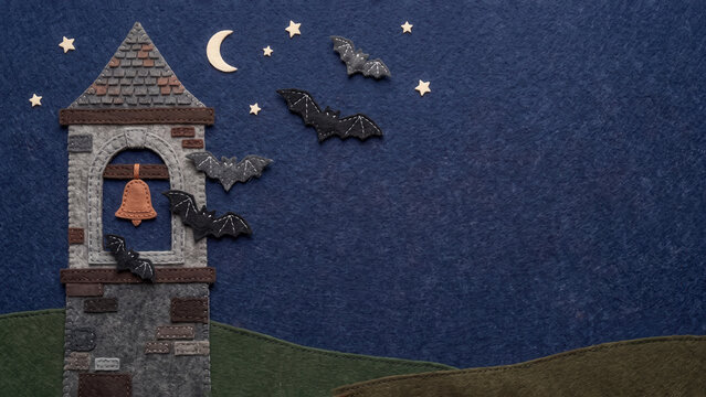 Five felt bats flying from a stitched stone bell tower under a starry night sky with a crescent moon, crafted on dark blue and green textured fabric.