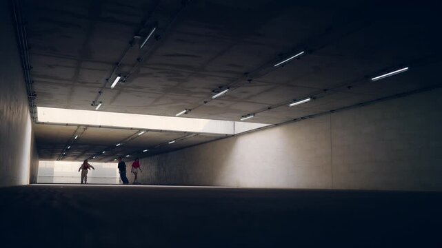 Asian people friends practicing longboard together in urban underpass enjoying outdoor active lifestyle improving skateboarding skills teamwork balance fitness and recreation extreme sport in the city