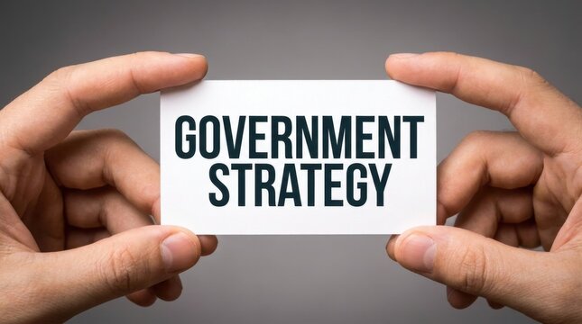 Two hands holding a white card with government strategy text against a grey background with administration implementation business
