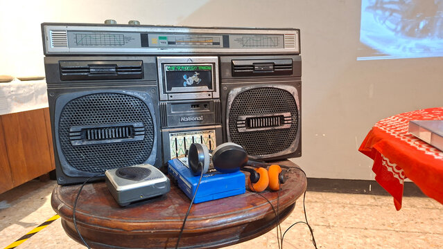 Vintage National Stereo Cassette Radio with Two Walkman Players on Wooden Table Retro Audio Equipment Collection
